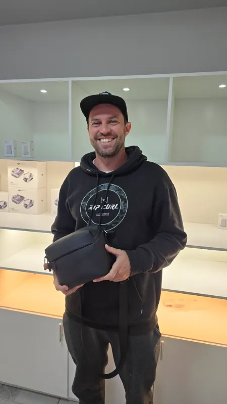 Cliente sorrindo com a bolsa do drone na loja